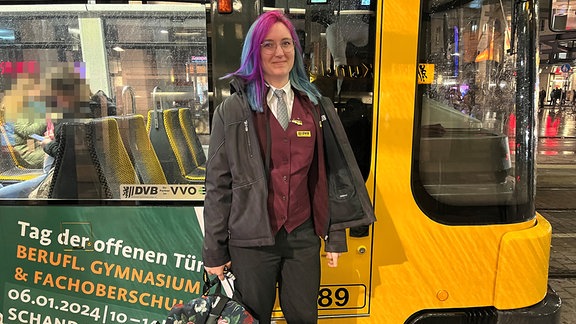 Eine junge Frau sitzt im Führerstand einer Straßenbahn. Eine junge Frau mit Uniform einen Straßenbahnfahrerin steht neben einer gelben Straßenbahn. 