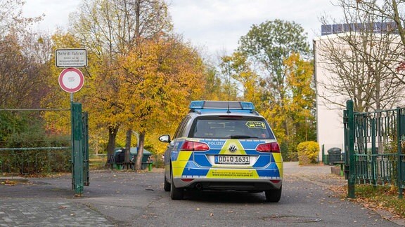 ein Streifenwagen steht vor einem Tor