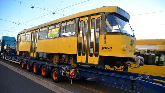 Gelbe Tatra-Bahn auf einem blauen Sattelzug