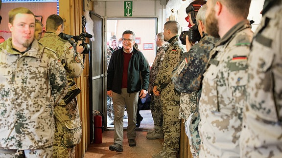 Der amtierende Bundesverteidigungsminister Thomas de Maiziere (CDU, M.) kommt am 11.12.2013 in das Camp Shaeen bei Masar-i-Scharif (Afghanistan) zum Truppenbesuch bei deutschen Soldaten.