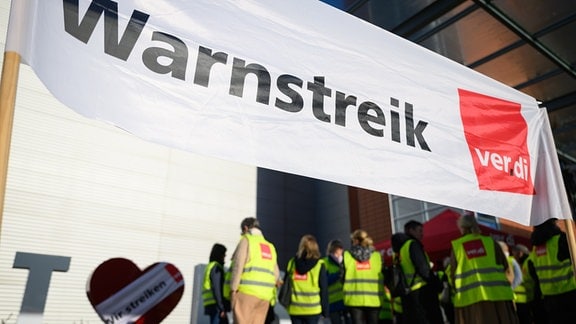 Beschäftigte der Lufthansa-Tochterunternehmen Airport Service Dresden GmbH (ASD) stehen beim Warnstreik der Dienstleistungsgewerkschaft Verdi vor dem Flughafen Dresden International.