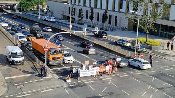 Menschen protestieren in Dresden gegen klimaschädliche Einsätze der Bundeswehr.