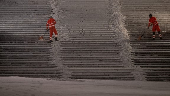 Mitarbeiter der Dresdner Stadtreinigung befreien am frühen Morgen die Treppen der Brühlschen Terrasse vom Schnee.