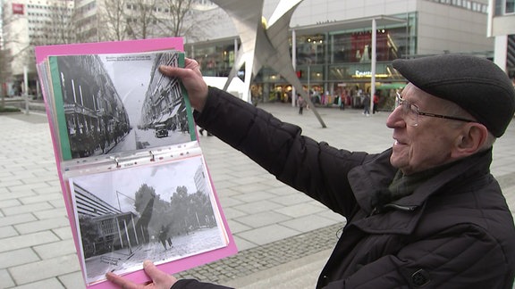 Ein älterer Mann zeigt eine Fotografie