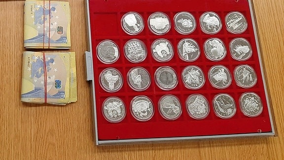 Geldscheine und Silbermünzen liegen auf einem Tisch 