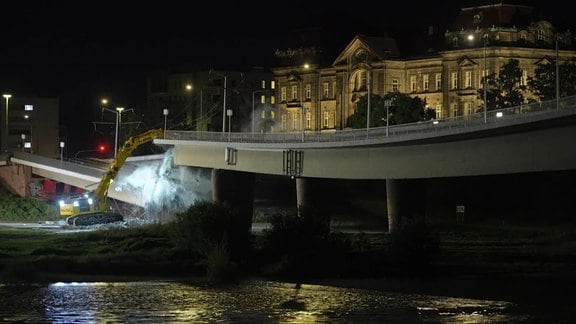 Bagger und Brücke die gerade einstürzt