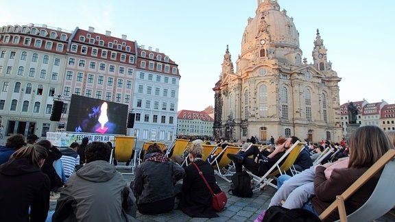 Publikum in Liegestühlöen auf dem Platz vor der Frauenkirche vor einer Kinoleinwand