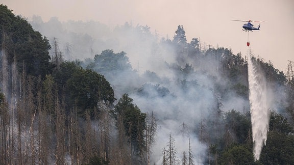 Mit einem Hubschrauber wird ein Waldbrand im tschechischen Nationalpark Böhmische Schweiz gelöscht