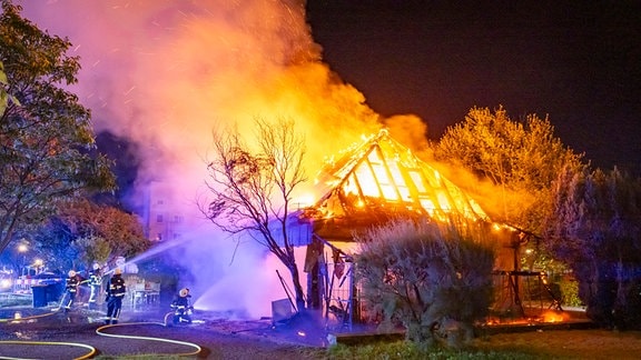 Die Feuerwehr löscht ein Gebäude. 