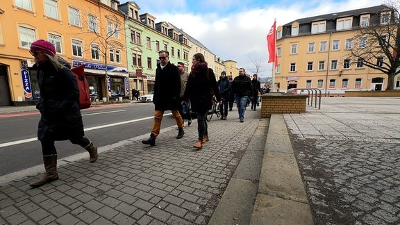 Menschen laufen eine Straße entlang