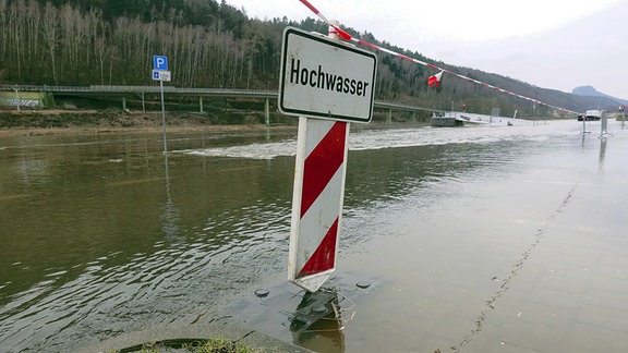 Straßensperrung mit Schild: "Hochwasser".