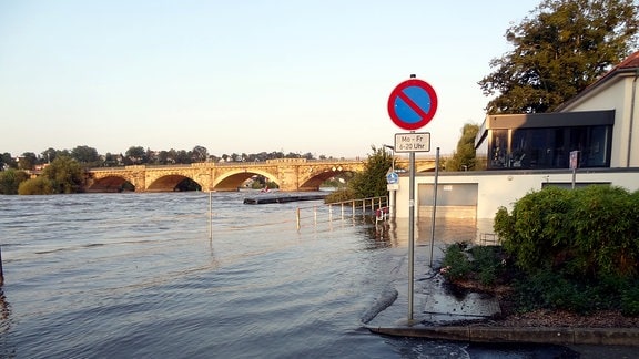 Das Hochwasser schwappt bis an ein Haus am Ufer heran. 