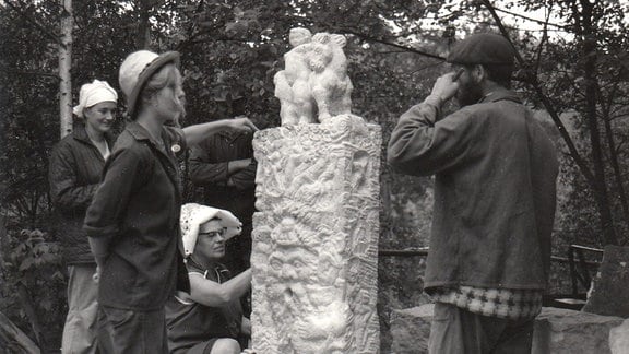 Bildhauerinnen und Bildhauer arbeiten an einer Skulptur