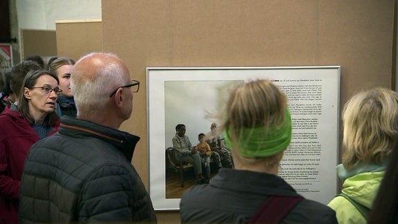 Besucher betrachtet eine Ausstellungswand.