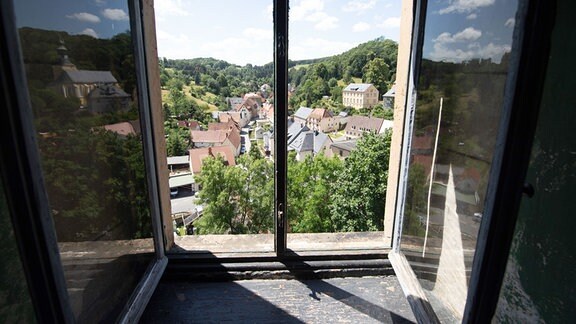 Blick durch ein offenes Fenster im Schloss Kuckuckstein auf die Gemeinde Liebstadt. 