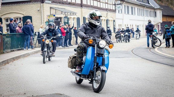 Ein Konvoi mit zahkreichen DDR-Mopeds fährt durch Bad Schandau.