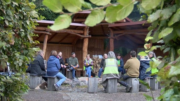 Menschen sitzen um ein Feuer