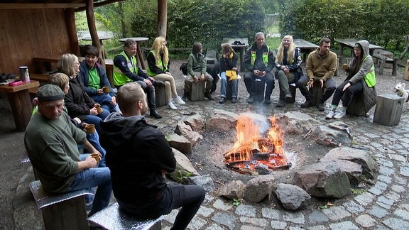 Menschen sitzen um ein Feuer