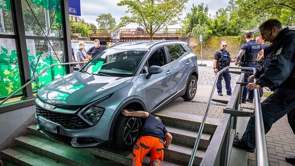 Ein verunglücktes Auto steht auf der Treppe einer Bahnunterführung