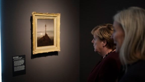  Bundeskanzlerin a. D. Angela Merkel (CDU, l) und Marion Ackermann, Generaldirektorin der Staatlichen Kunstsammlungen Dresden, stehen vor einem Gemälde von Caspar David Friedrich in der Ausstellung «Caspar David Friedrich. Wo alles begann» im Albertinum Dresden. 