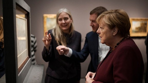 Bundeskanzlerin a. D. Angela Merkel (r-l, Sachsens Ministerpräsident Michael Kretschmer (CDU) und Marion Ackermann, Generaldirektorin der Staatlichen Kunstsammlungen Dresden, stehen vor einem Bild in der Ausstellung «Caspar David Friedrich. 