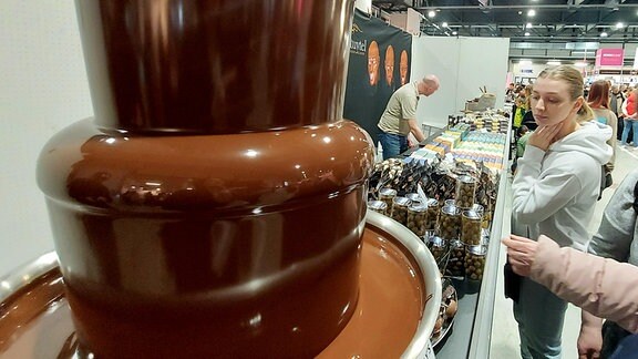 An einem Messestand gleitet hellbraune Schokolade unaufhörlich über 3 Etagen des Schokobrunnens nach unten. Ob man seinen finger mal hineinhalten könnte? Das fragten sich viele Besucherinnen spontan.