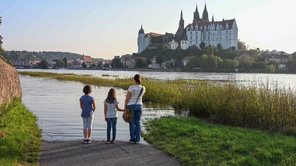 Eine Frau und zwei Kinder stehen an der Elbe in Meißen, die Hochwasser führt. 