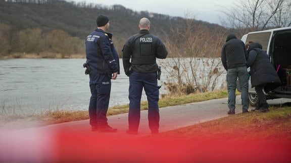 Polizisten am Ufer der Elbe