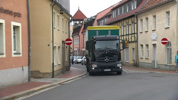 Ein Lkw fährt durch einen dicht bebauten Ort. 
