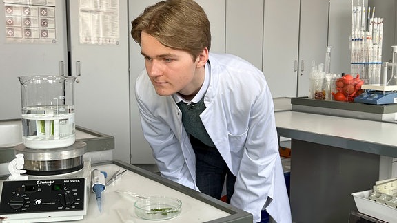 Junger Mann steht in einem Labor