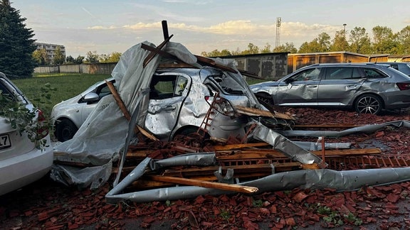 Mehrere Autos sind stark beschädigt worden - wohl von Dachbalken, die von einem Neubaublock geweht wurden.
