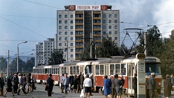 Tatra Straßenbahn an der Haltestelle Postplatz und Neubaublock mit sozialistischem Slogan in Dresden.