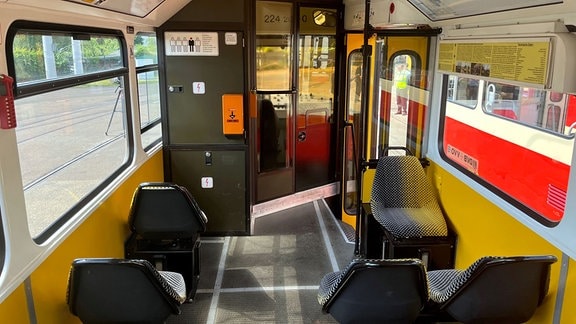 Fahrgastraum mit Sitzen in einer Strassenbahn der Baureihe Tatra.