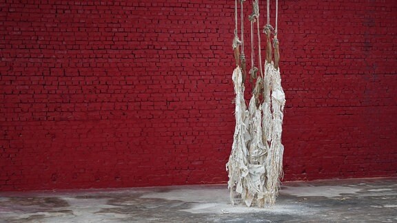 Eine von der Decke hängende Kunstinstallation von Dominique White aus abgenutzten handgewobenen Netzen, erschlafften Bojen und Bast.  