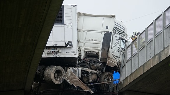 Ein Lastwagen hängt an einer Brücke fest.