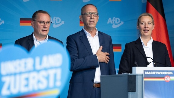 Tino Chrupalla (l-r), AfD-Bundesvorsitzender und Fraktionsvorsitzender der AfD, Jörg Urban, Vorsitzender der AfD in Sachsen, und Alice Weidel, AfD-Bundesvorsitzende, stehen auf einer Wahlkampfveranstaltung ihrer Partei auf dem Theaterplatz auf der Bühne und singen die deutsche Nationalhymne. Am 1. September 2024 wird in Sachsen ein neuer Landtag gewählt.