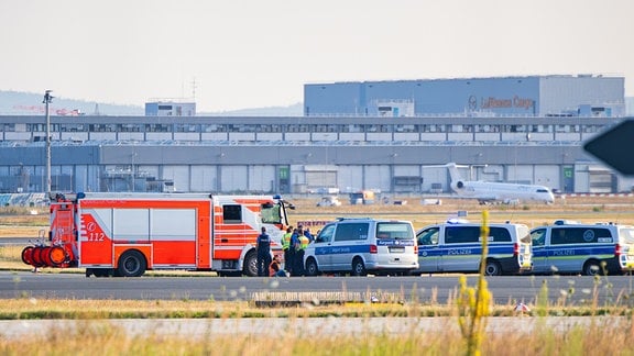 Einsatzfahrzeuge der Polizei stehen am Frankfurter Flughafen bei einer Aktion von Klimaaktivisten.