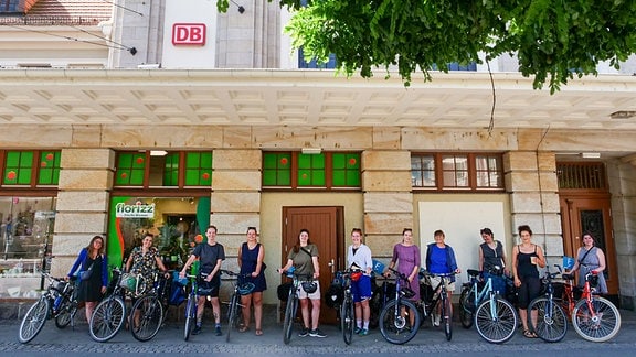 Gruppenbild von Radlerinnen vor einem Bahnhofsgebäude