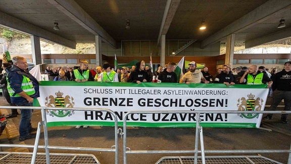 Anhänger der Kleinstpartei Freie Sachsen halten ein Banner mit der Aufschrift "Schluss mit Illegaler Einwanderung Grenze Geschlossen Hranice Uzavřena. 