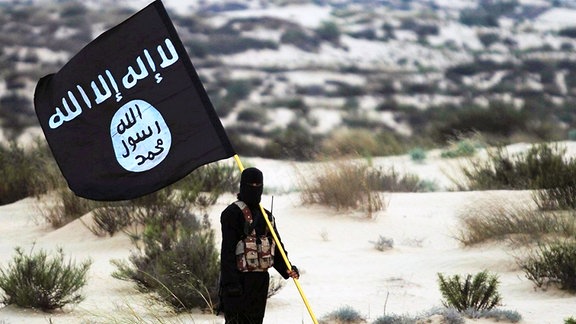 IS Kämpfer trägt Flagge.