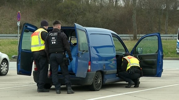 Polizisten kontrollieren Fahrzeug