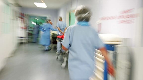 Eine Krankenschwester eilt durch einen Krankenhausflur