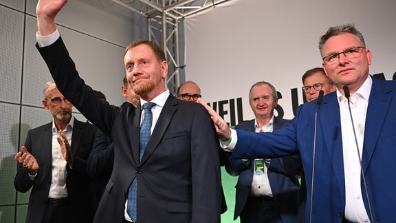 Michael Kretschmer (CDU), amtierender Ministerpräsident von Sachsen und Spitzenkandidat, winkt neben Christian Hartmann (r, CDU), Fraktionsvorsitzender im Sächsischen Landtag