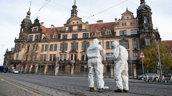 Zwei Mitarbeiter der Spurensicherung stehen 2019 vor dem Residenzschloss mit dem Grünen Gewölbe. 