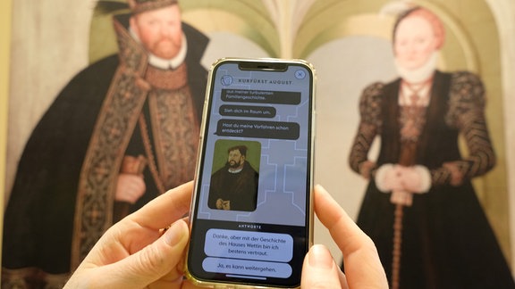 Auf einem Handy wird eine App mit dem Bild von Kurfürst August von Sachsen gezeigt.