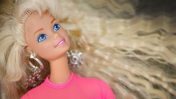 Barbie-Puppe mit blondem Haar und rosa Oberteil.