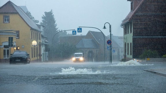 Autos fahren über eine überschwemmte Straße