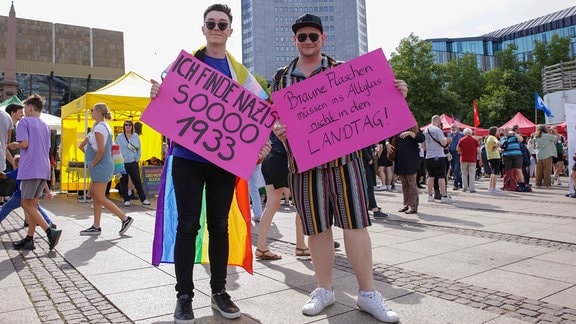 Brandmauer Demo Leipzig, zwei junge Männer halten Plakate