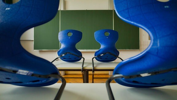 Leeres Klassenzimmer mit hoch gestellten Stühlen.