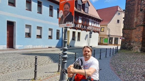 SPD-Stadtratskandidat in Delitzsch, Christian Gwenner, vor einem seiner Wahlplakate in der Innenstadt von Delitzsch